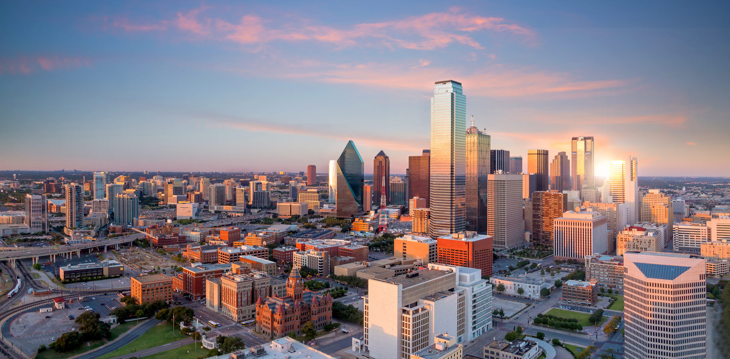 Dallas, Texas cityscape with blue sky at sunset in USA.